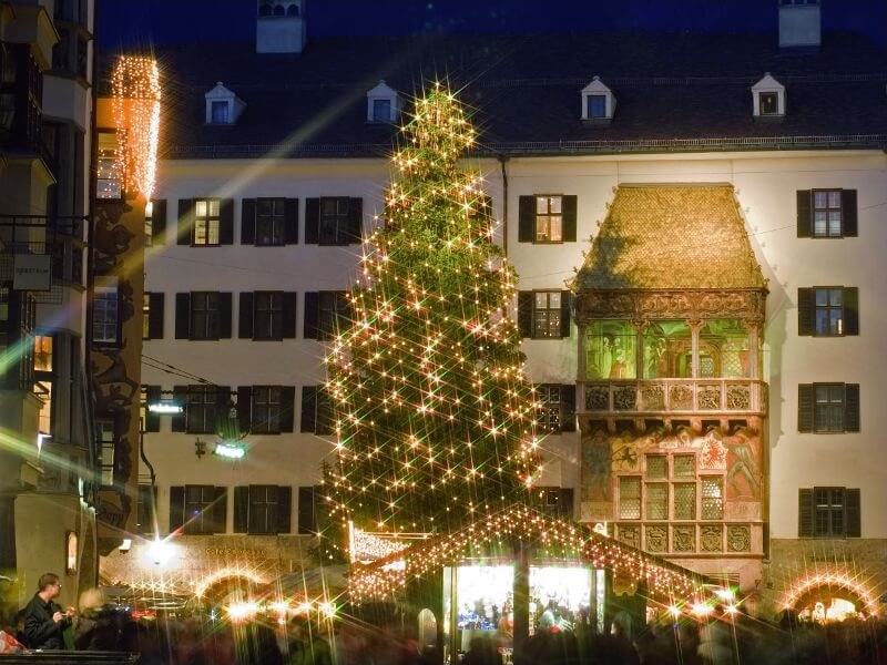 En bild av det berömda torget i gamla staden i Innsbruck, med den årliga julmarknaden och julgranen