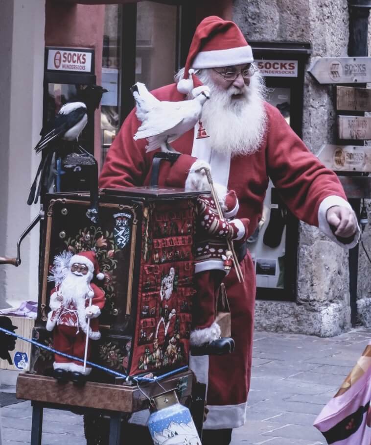 Bild av jultomte som sprider julglädje på ett torg i Innsbruck